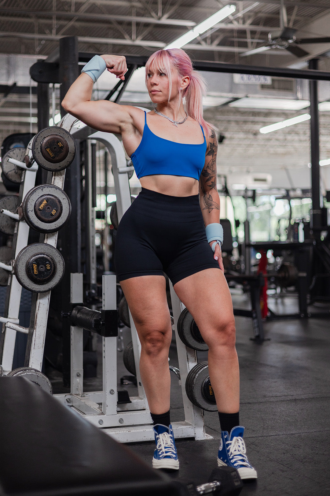 woman flexing bicep wearing uppper wrist wraps