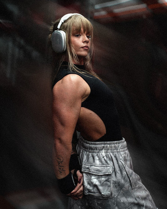 woman flexing tricep muscles wearing uppper wrist wraps