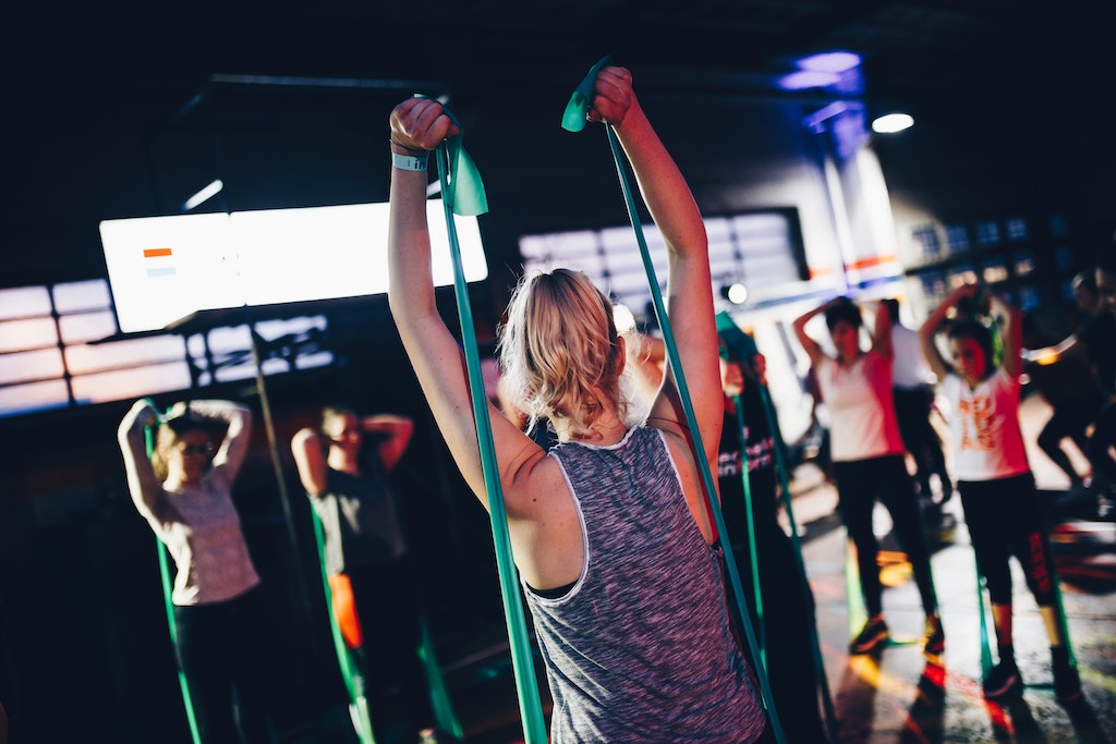 women doing upper body resistance band workout